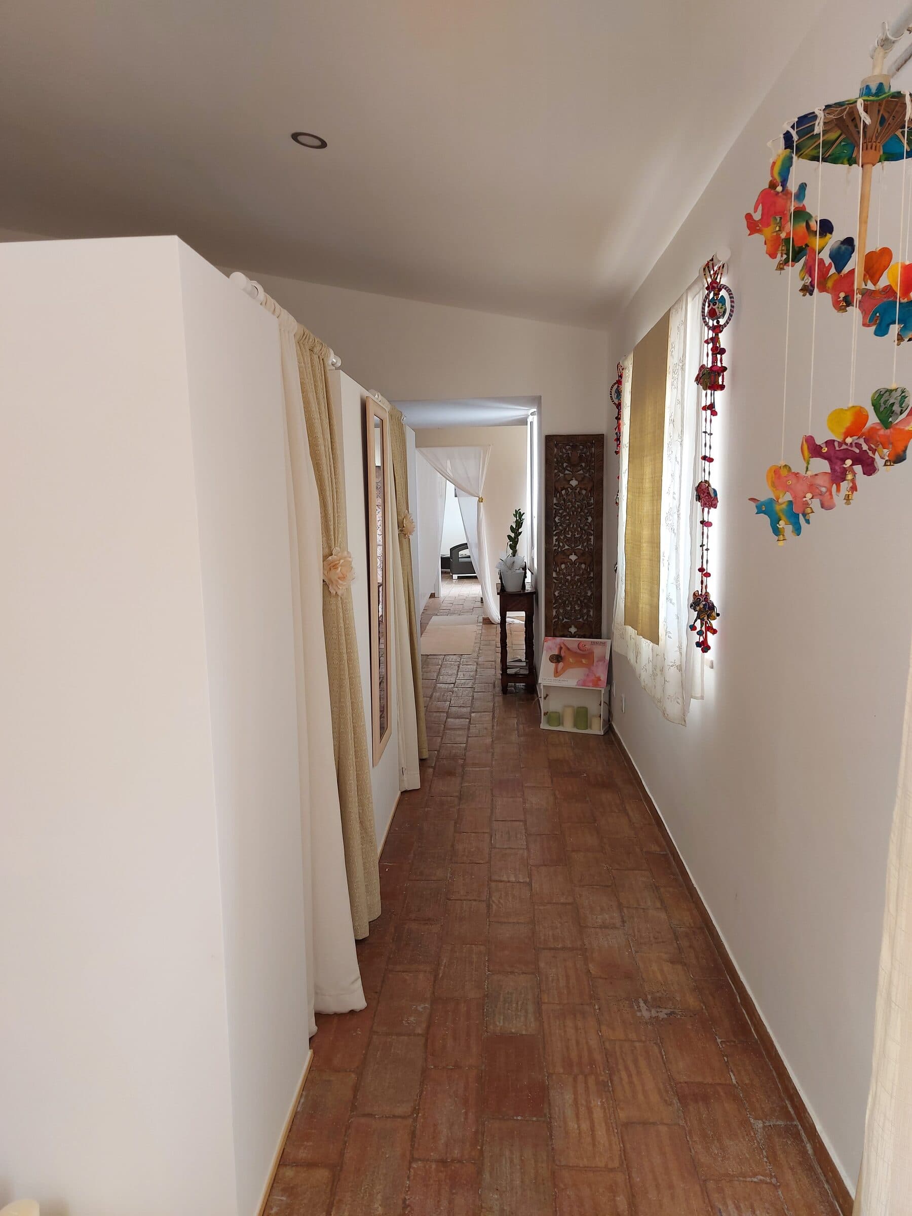 A hallway leading to the treatment rooms, with a colourful windchime