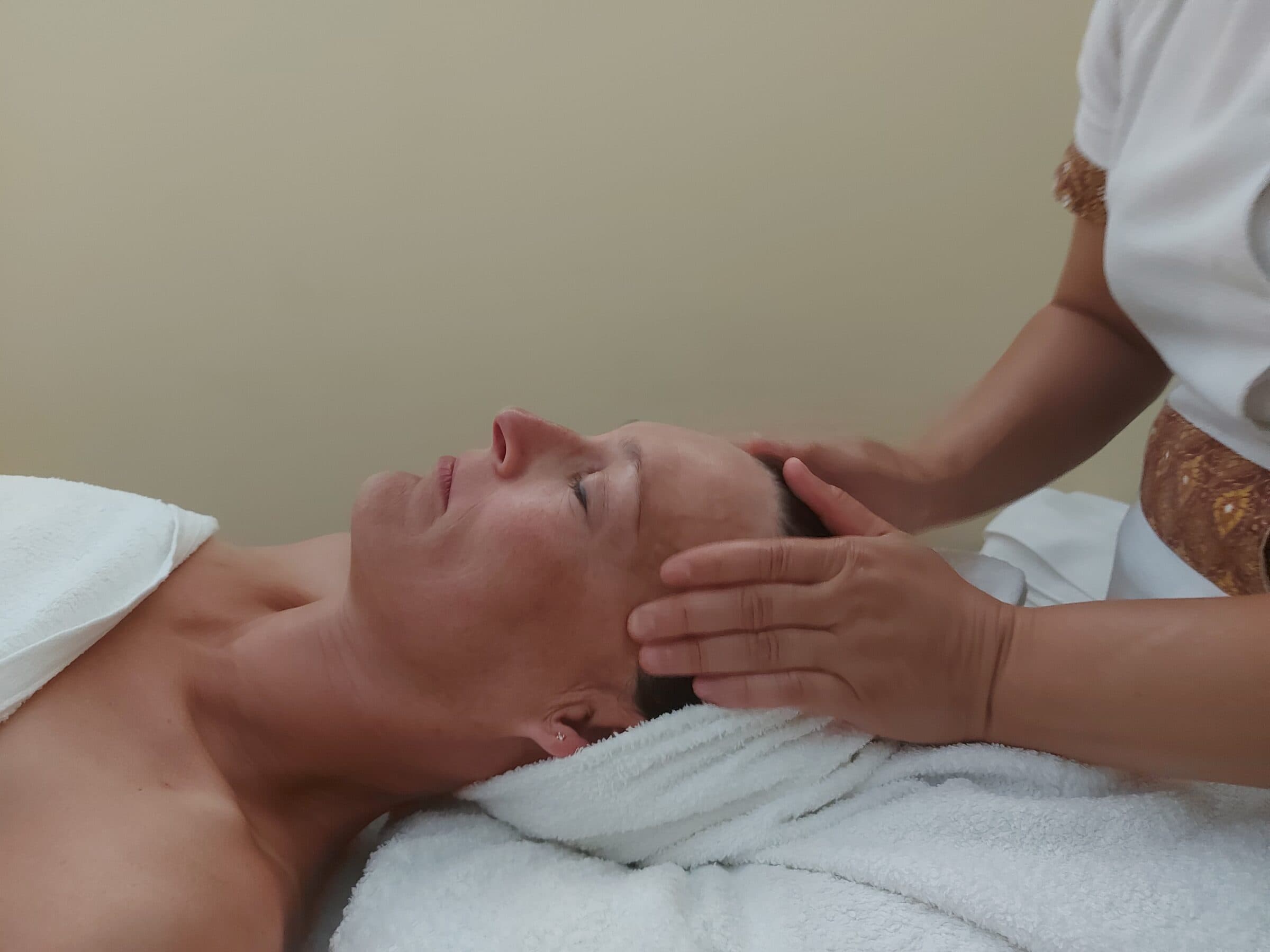 A guest receiving a head massage in profile