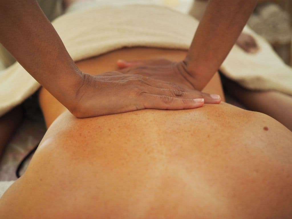 A guest receiving a full body relaxing massage, hands working across the back