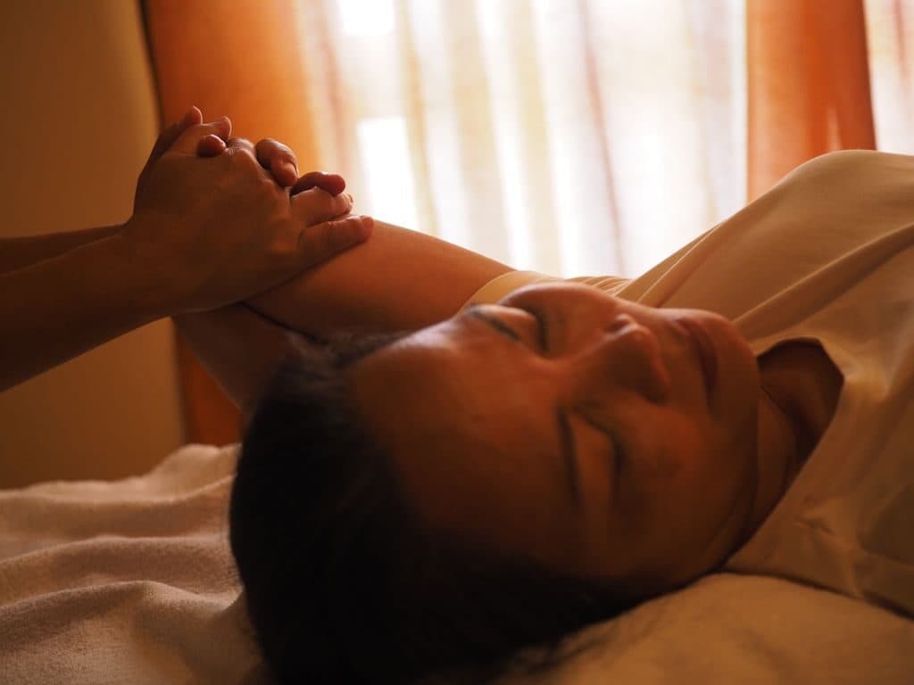 A therapist cradling a reclined guest's head during a traditional Thai massage